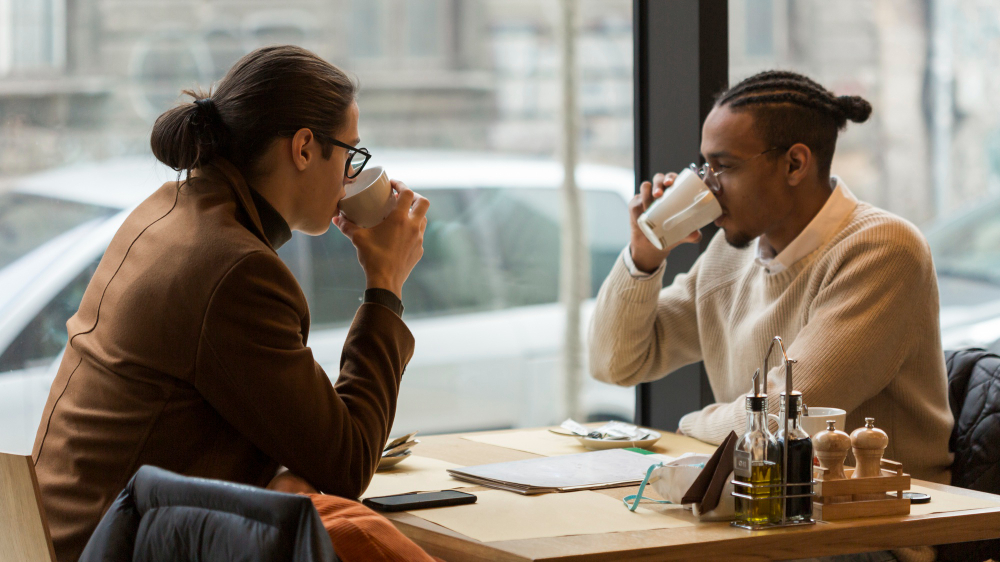 Two people talking over coffee.